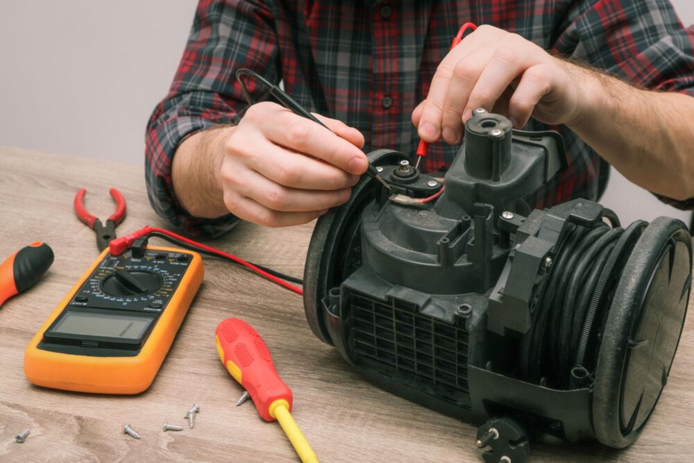 Professional technician repairing a vacuum cleaner in a workshop